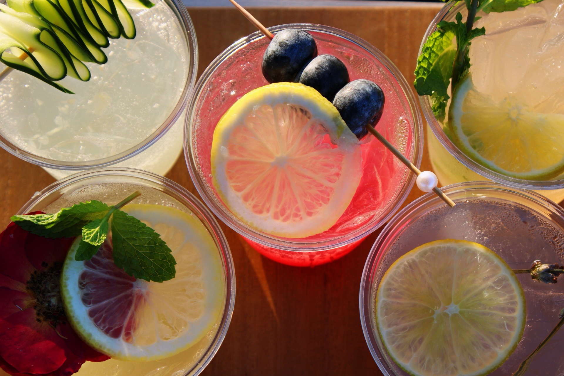 An overhead arrangement of five garnished cocktails