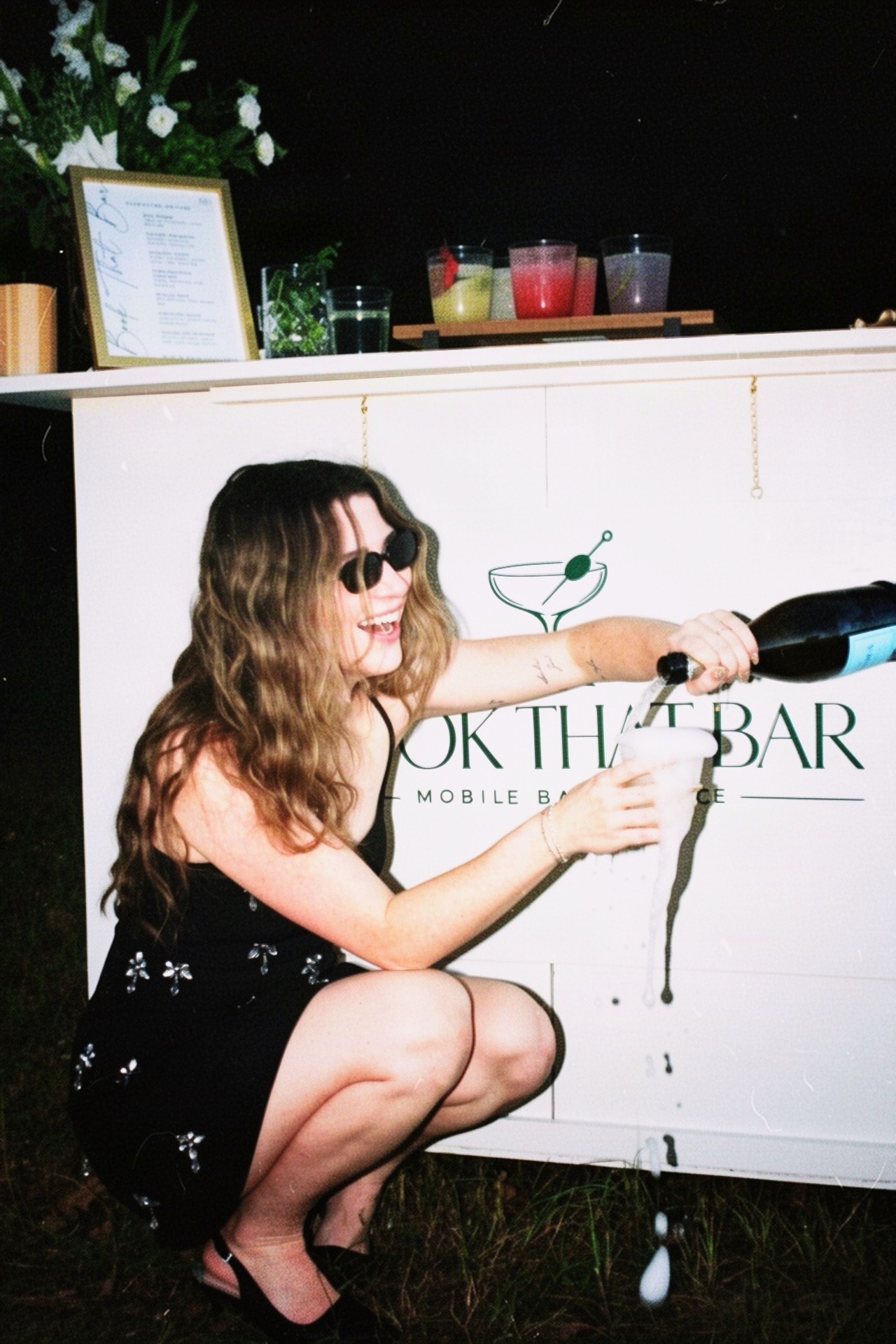 Morgan playfully pouring champagne beside the mobile bar
