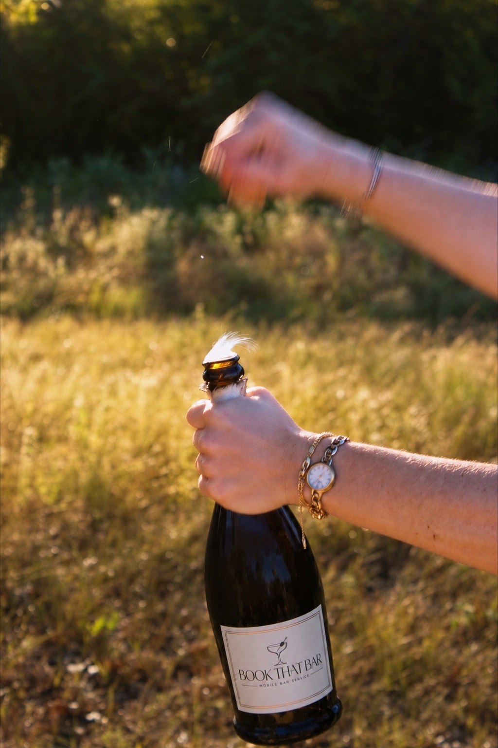 A champagne bottle being opened in the golden evening light