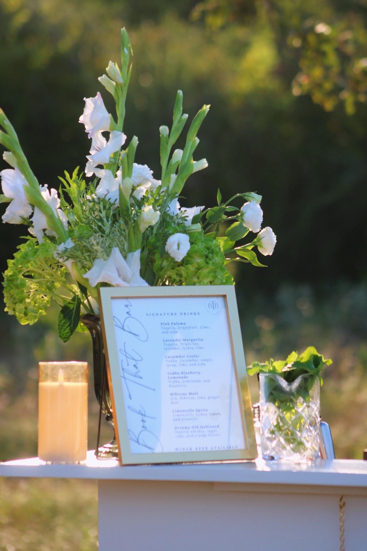 A signature drink menu styled with white flowers and mint