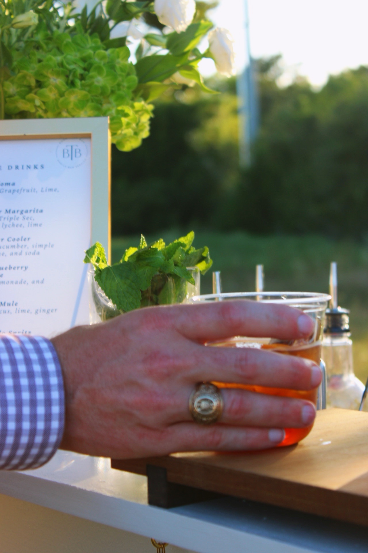 A guest reaching for a cocktail at the bar