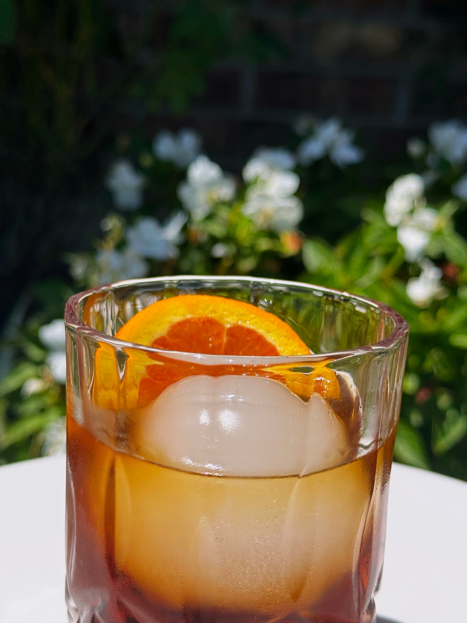 Maple Old-Fashioned with an orange garnish and round ice cube