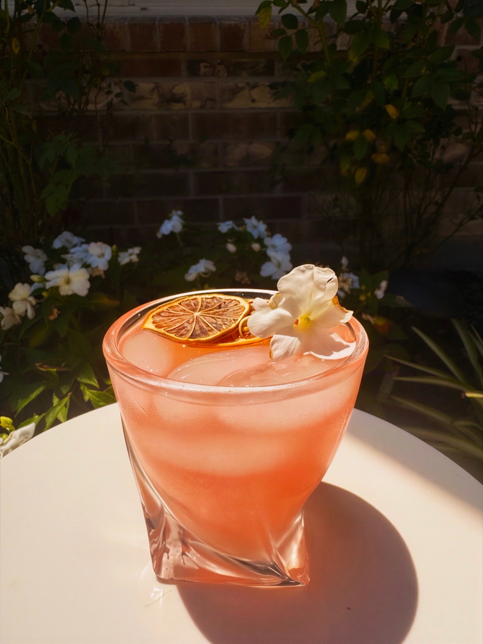 Pink Paloma with a dried citrus wheel and flower garnish