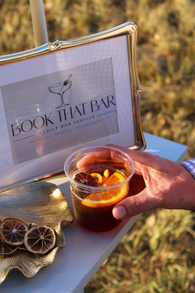 Maple Old-Fashioned beside a framed Book That Bar sign
